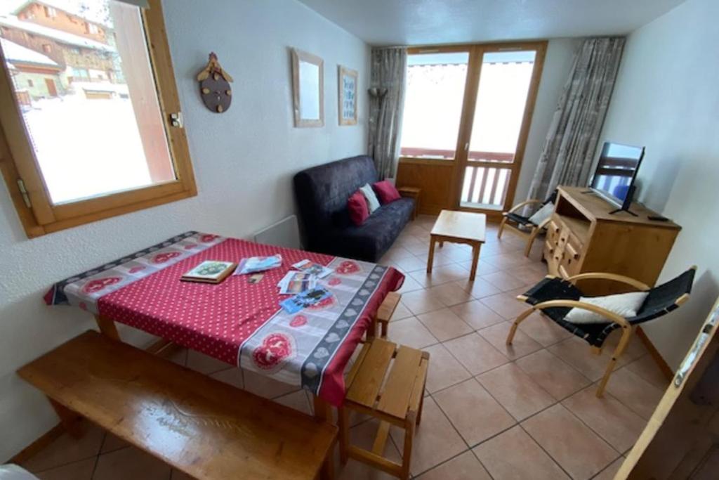 a small living room with a table and a chair at le signal 105 apartment in residence 50 meters from slopes 4-6 people in Montalbert