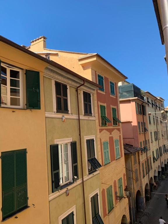 eine Reihe von Gebäuden mit grünen Türen und Fenstern in der Unterkunft Appartamento Veneto by Vacanze in Chiavari in Chiavari