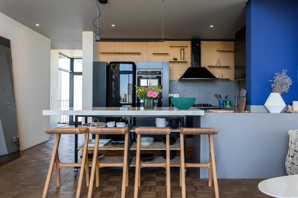a kitchen with a counter and stools in a room at Polo Village 8 Val de Vie Estate in Paarl
