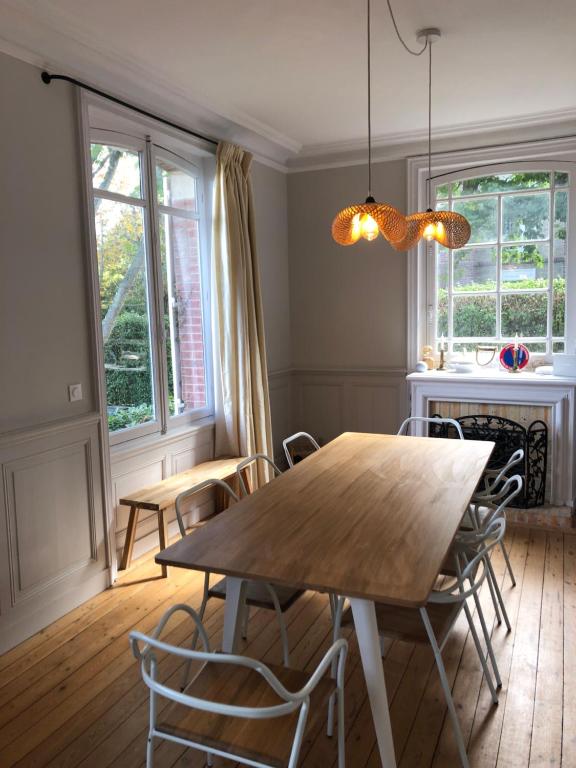 uma sala de jantar com uma mesa de madeira e cadeiras em Chantemerle à partir de 2 personnes em Villers-sur-Mer