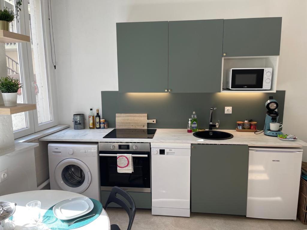 a kitchen with a washing machine and a microwave at LE PRESTRE in Besançon