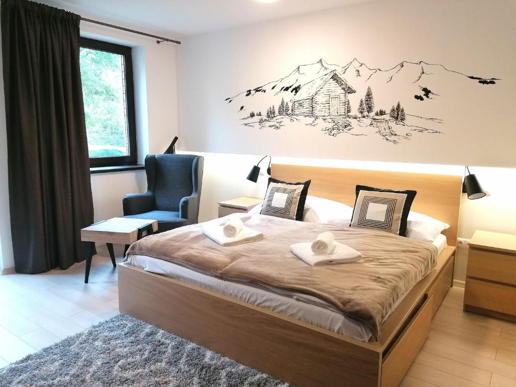 ein Schlafzimmer mit einem großen Bett und einem Stuhl in der Unterkunft Penzión ** Kolkáreň in Vyhne