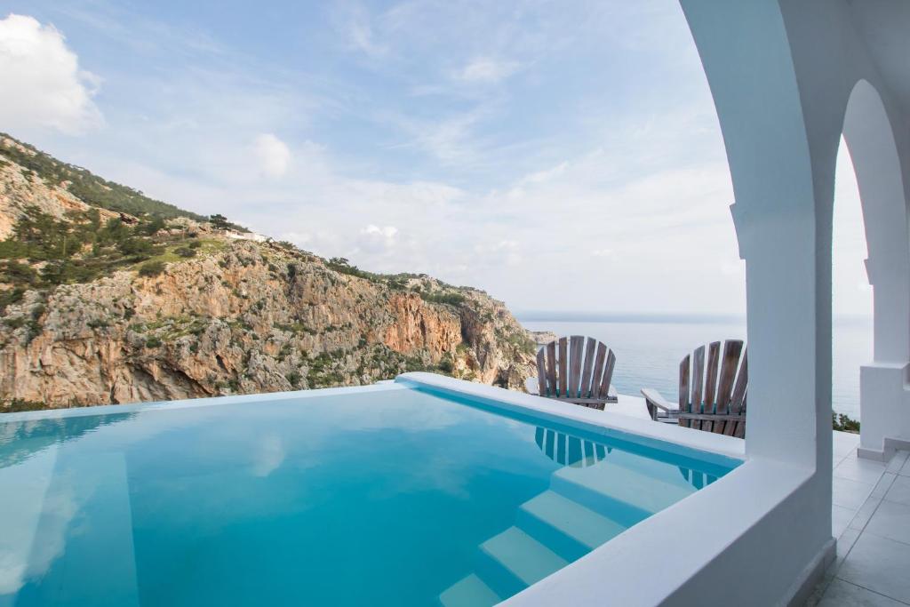 uma villa com piscina e vista para o oceano em Vento Isolano suites em Cárpatos