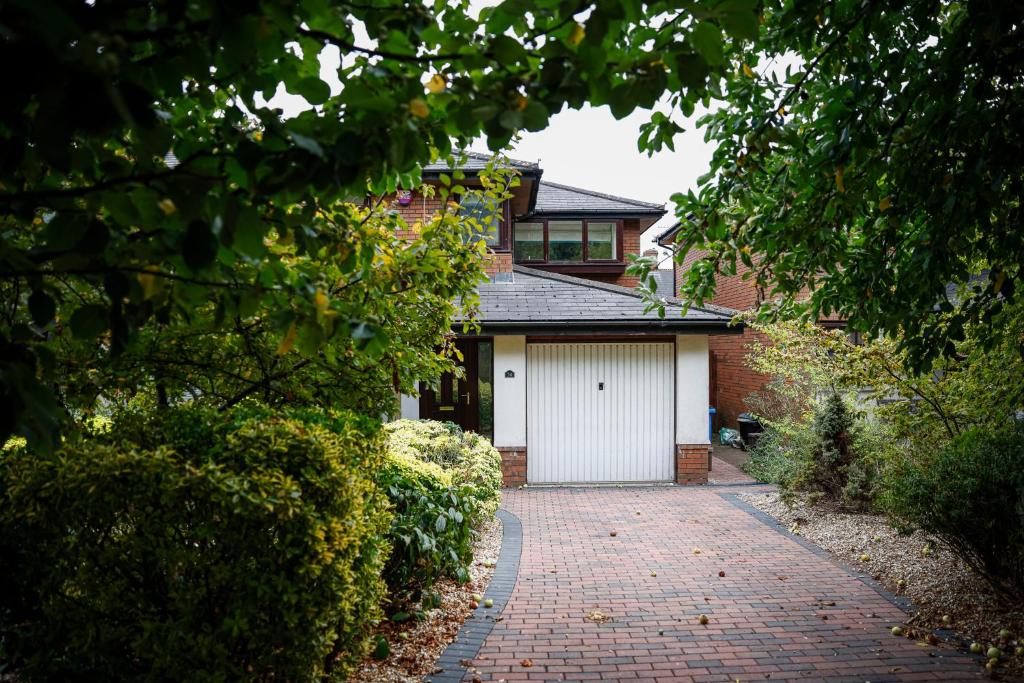 una casa con garaje blanco y entrada de ladrillo en Stylish family home in desirable Penylan + Parking, en Cardiff