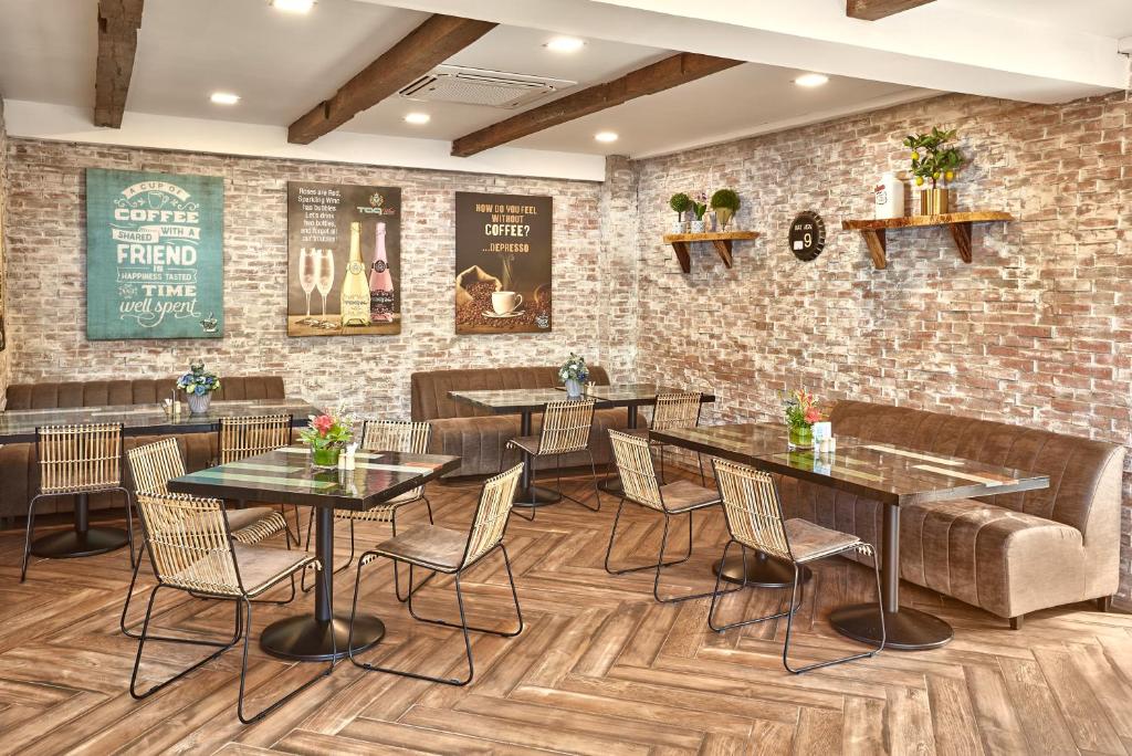 a restaurant with tables and chairs and a brick wall at Tag Resort in Coron