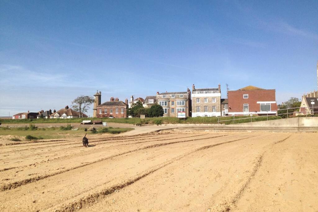 a person standing in the middle of a dirt road at Sea Breeze is next to the Beach & Harbour in Harwich