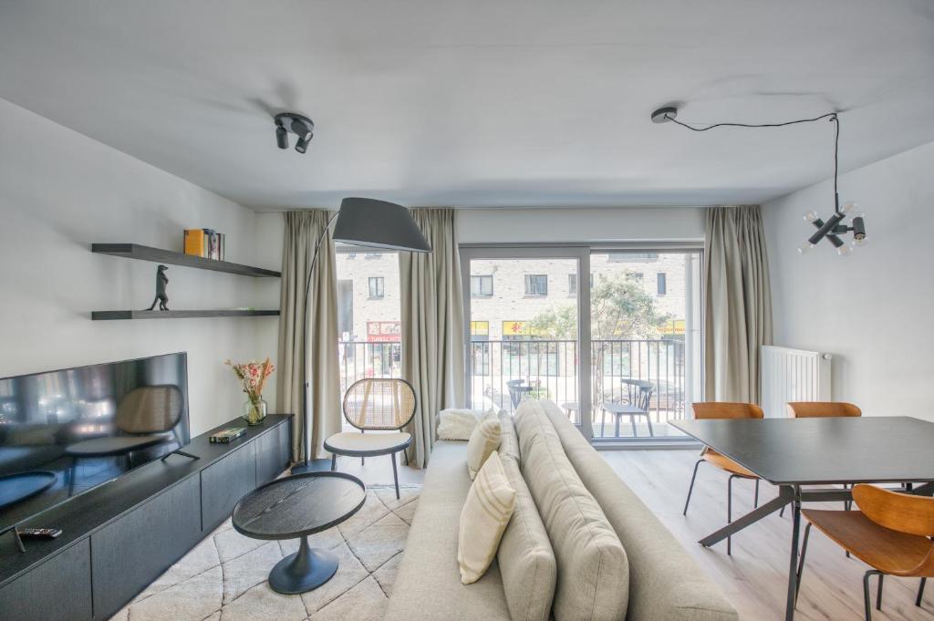 sala de estar con sofá grande y mesa en Cosy Seaside Apartments en Ostende