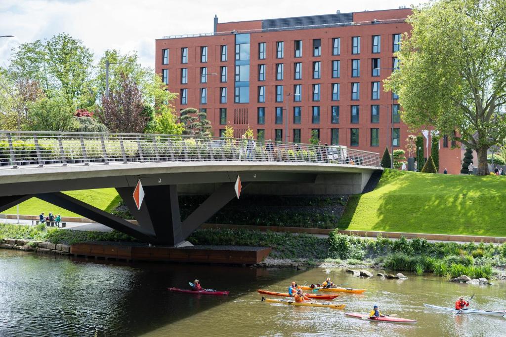 un groupe de personnes faisant du canoë-kayak sur une rivière sous un pont dans l'établissement Jugendherberge Heilbronn, à Heilbronn