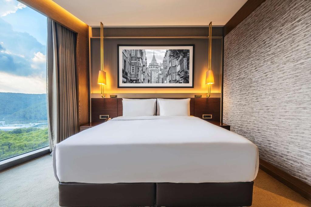 a large bed in a room with a large window at Radisson Collection Hotel, Vadistanbul in Istanbul