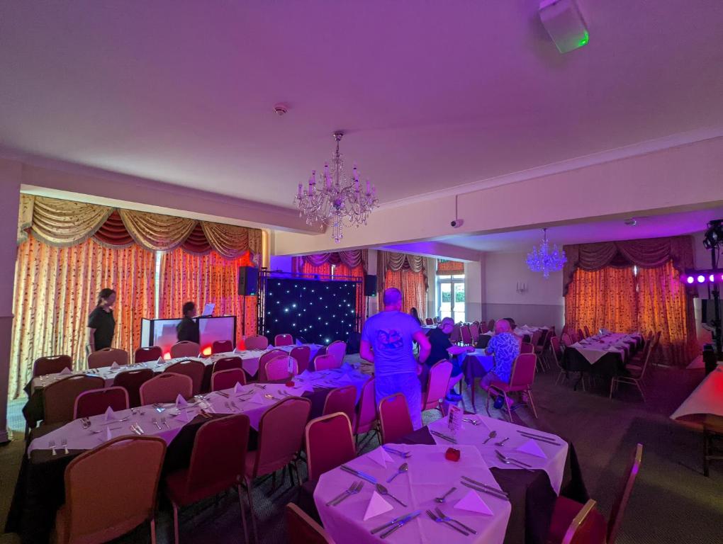 a room filled with tables and chairs with purple lighting at The Grove Hotel in Bournemouth