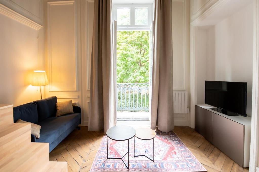 a living room with a blue couch and a window at Le Chavannes -Ecrin élégant & Cosy - Pentes de la Croix Rousse in Lyon