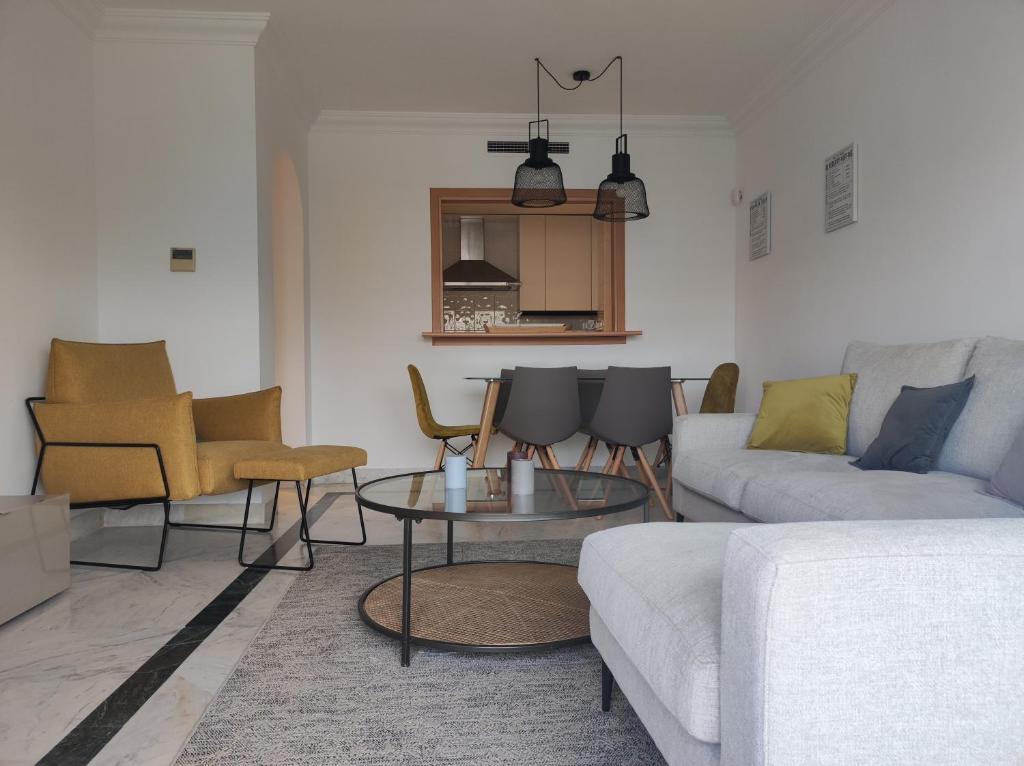 een woonkamer met een bank en een tafel en stoelen bij HomelyStay - Marbella, Marina Banus in Marbella