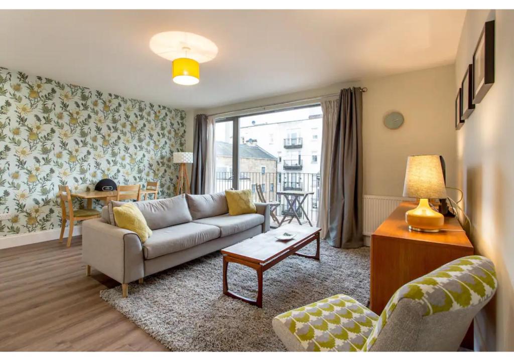 a living room with a couch and a table at JOIVY Chic flat with balcony in Merchant City in Glasgow