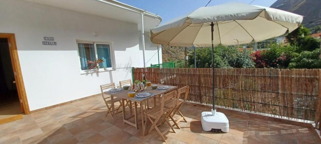 a table with an umbrella on a patio at Casa Efraim in Hermigua