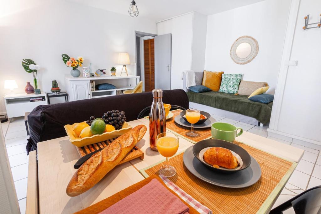 a table with food and drinks on it in a living room at Le Clos des Rosiers in Toulouse