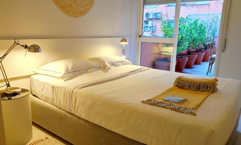a bedroom with a large white bed and a window at Naty Studio with Terrace in Vila Nova de Famalicão
