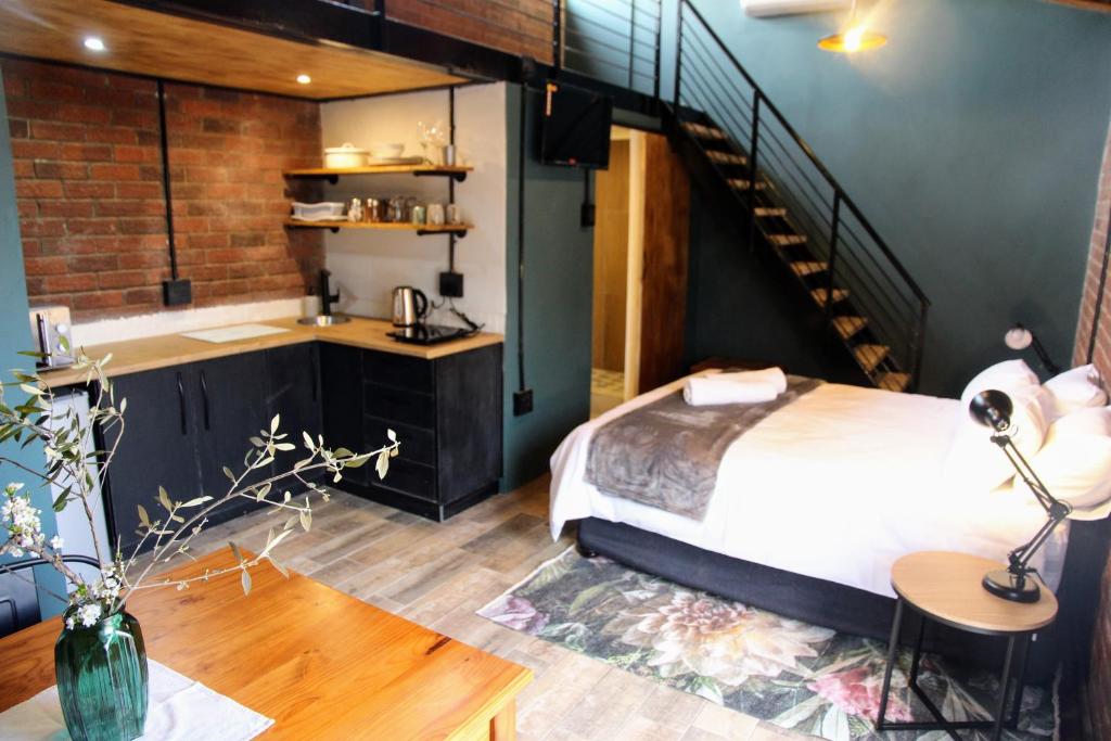1 dormitorio con 1 cama y escalera. en Nini's guest units en Bloemfontein