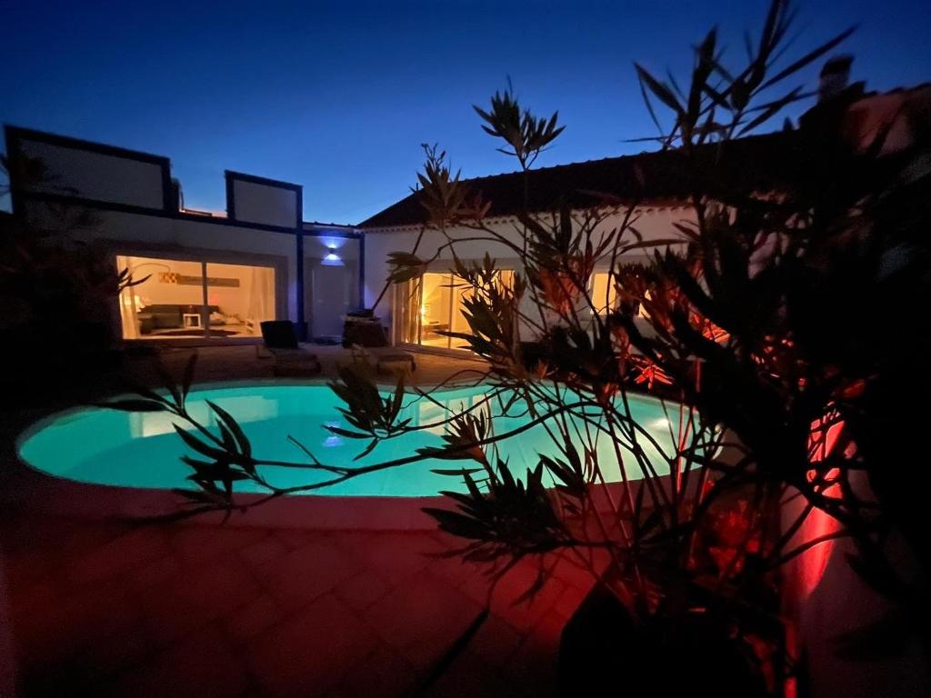 a house with a swimming pool at night at Joia da Casa in Sobral