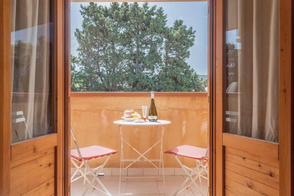 un patio con tavolo, sedie e finestra di San Carlo - private beach a Palermo