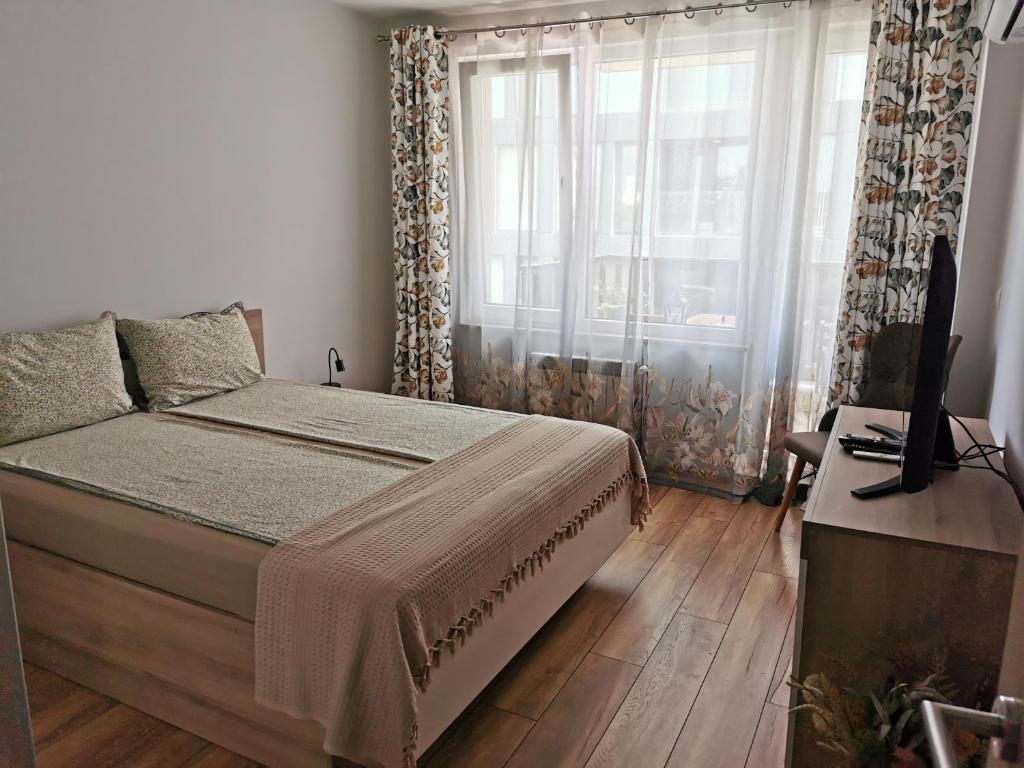 a bedroom with a bed and a large window at Brand new apartment with free parking near city center in Sofia