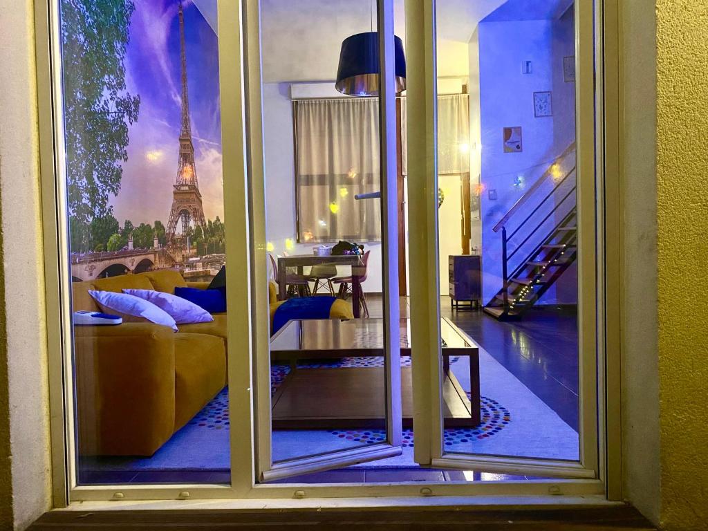 a room with a view of the eiffel tower through a window at Magnifique VILLA avec jacuzzi au pied du STADE in Saint-Denis