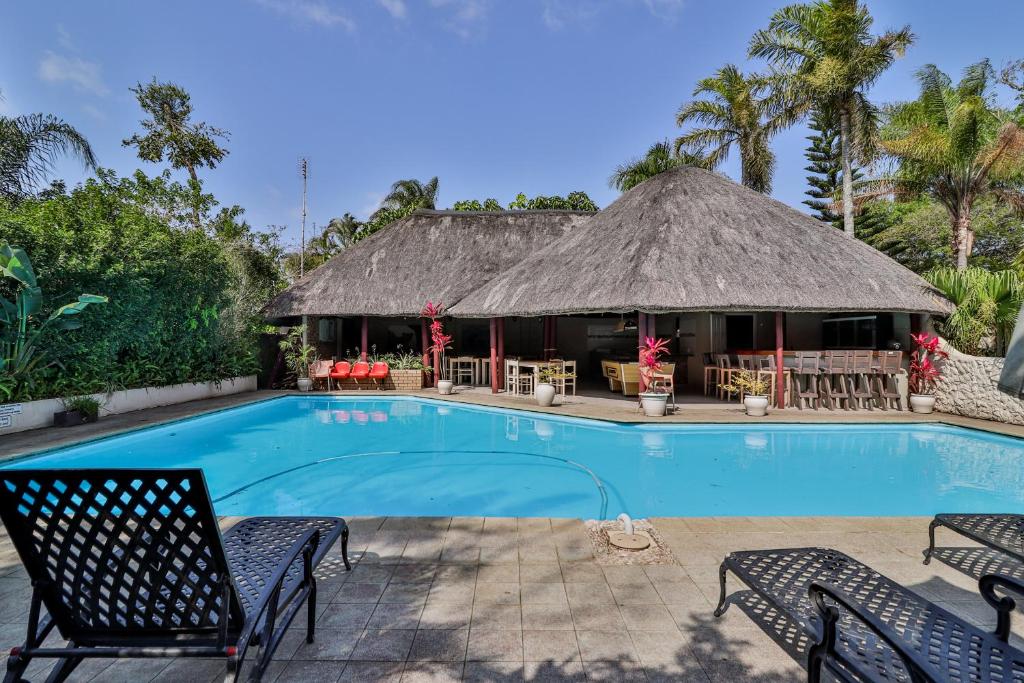 a resort with a swimming pool and a hut at St Lucia Safari Lodge Holiday Home in St Lucia