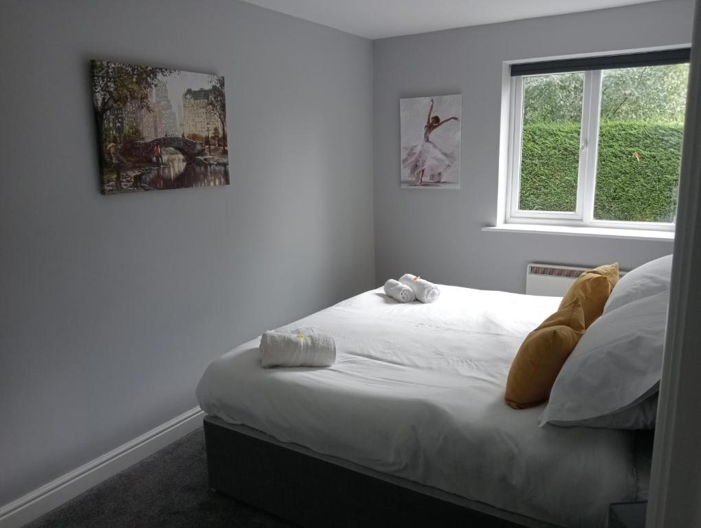 a bedroom with a bed with white sheets and a window at Green Street Retreat in York