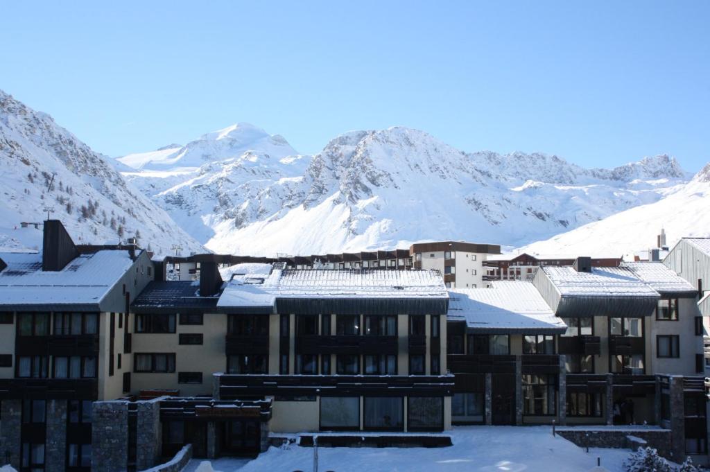 een groep gebouwen met sneeuw bedekte bergen op de achtergrond bij Appartement T3 pour 6 personnes in Tignes