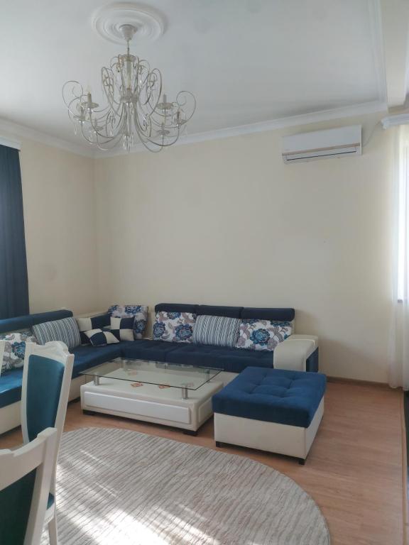 a living room with a blue couch and a chandelier at D&G guest house in Yeghegnadzor