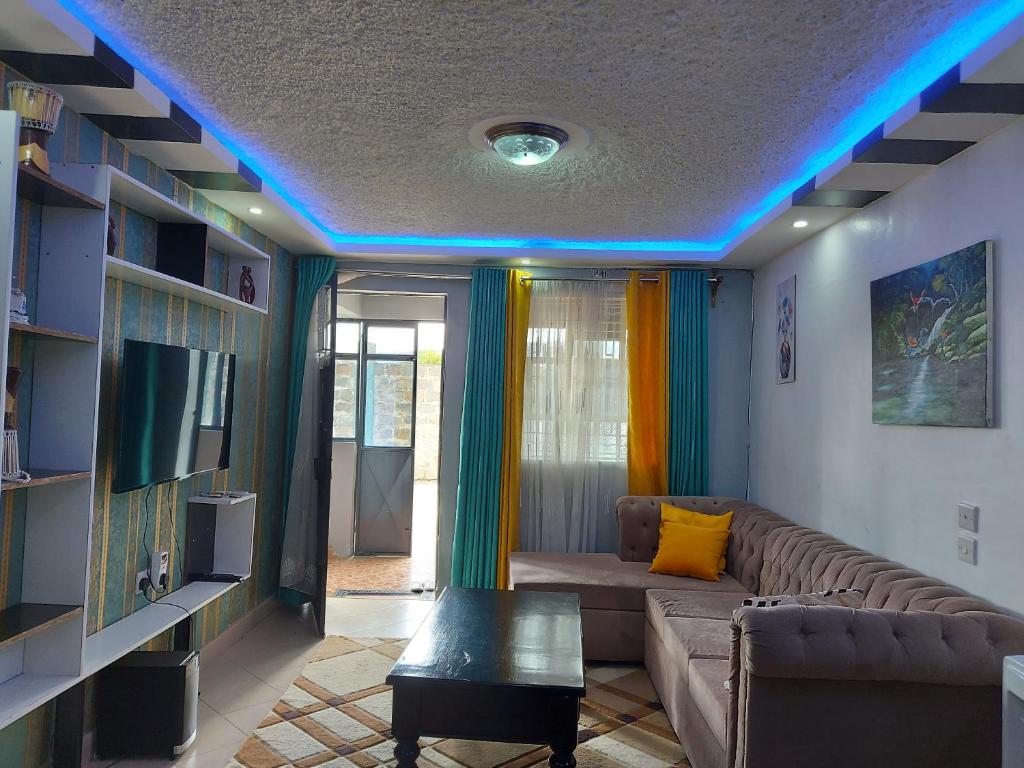 een woonkamer met een bank en een blauw licht bij Parkview apartments in Nakuru