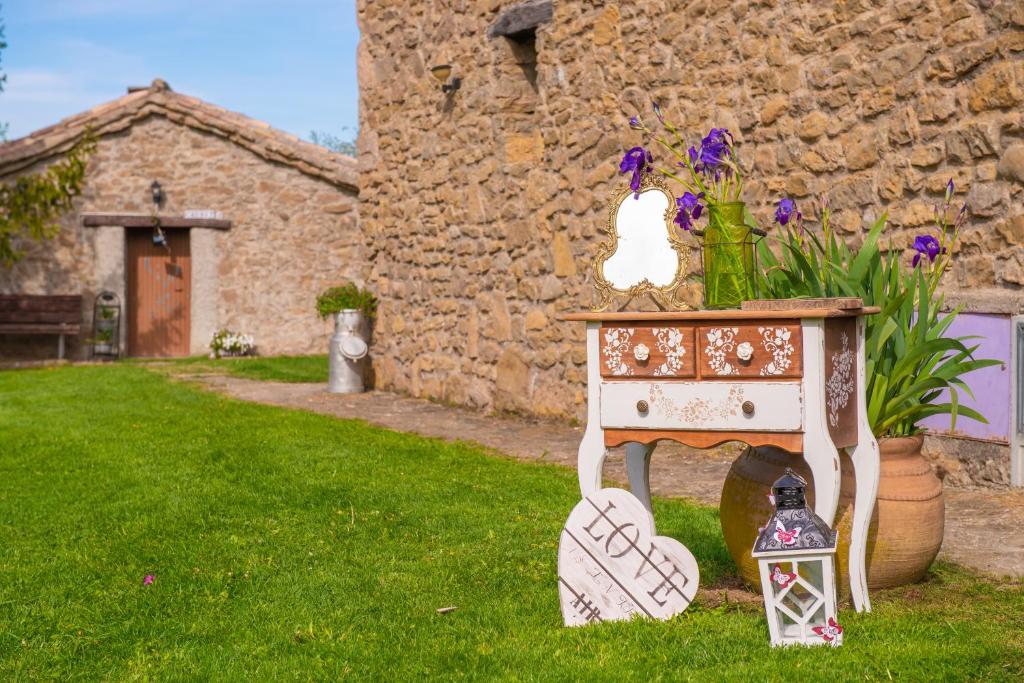 una pequeña mesa en un patio junto a un edificio de piedra en Complex Rural Can Caubet, en Berga