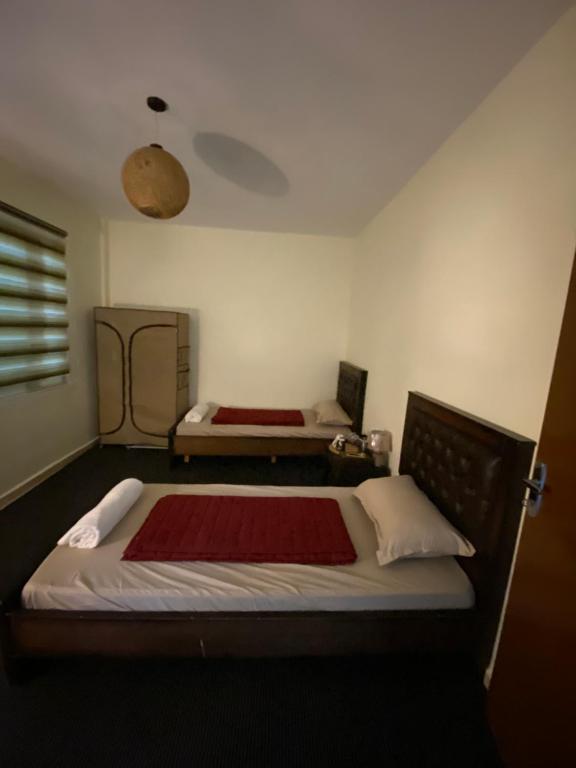 a bedroom with a bed with a red blanket at Hustle's look in Wadi Musa
