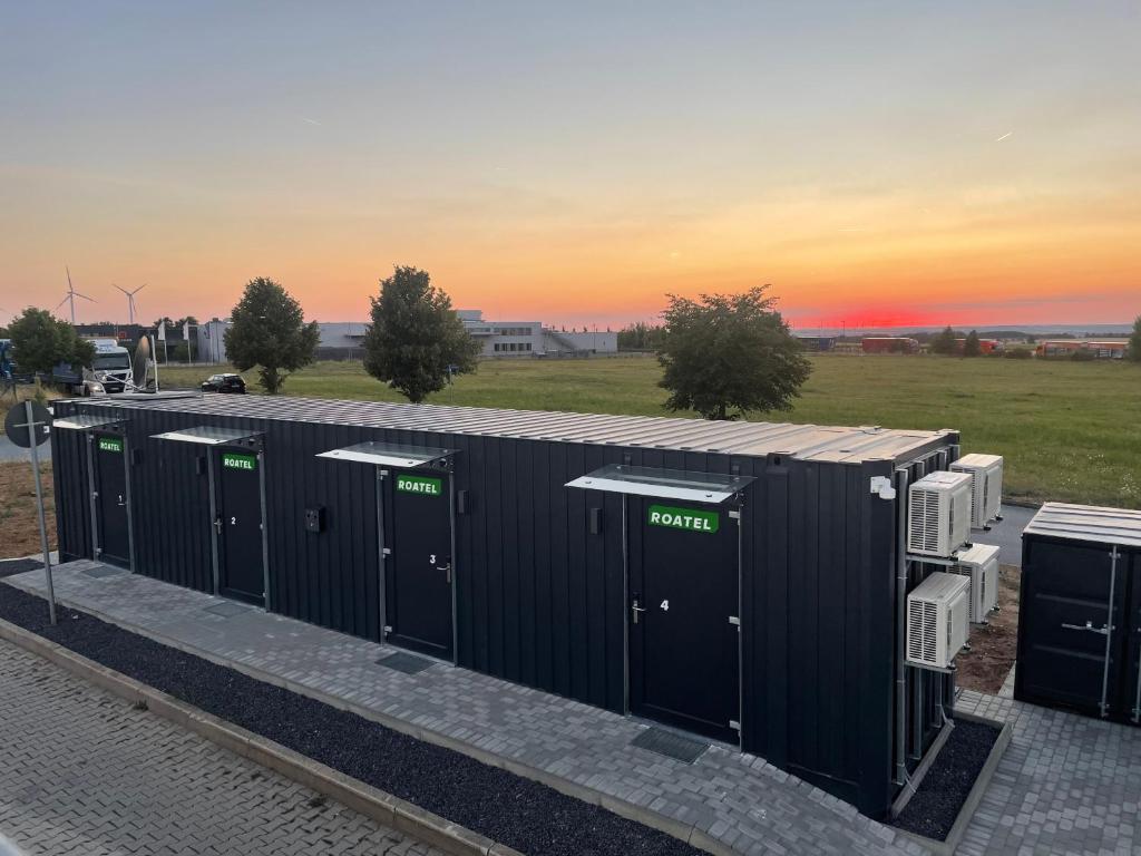 a row of portable toilets with the sunset in the background at Roatel Osterfeld A9 my-roatel-com in Kleinhelmsdorf