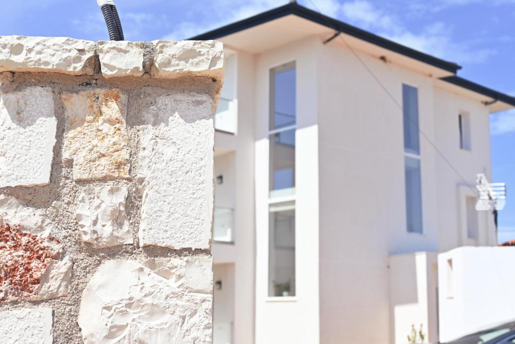 a brick wall in front of a white building at SEA & LAKE VIEW VILLA in (( Kalive Gjoka ))