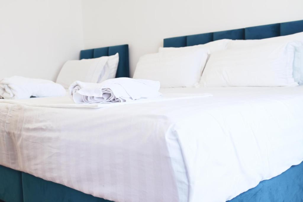 a large white bed with white sheets and pillows at SEA & LAKE VIEW VILLA in (( Kalive Gjoka ))