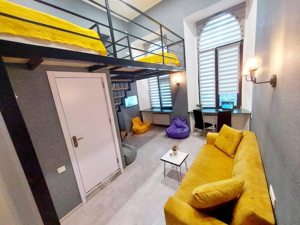 a living room with a yellow couch and bunk beds at The Passenger Rooms in Tbilisi City