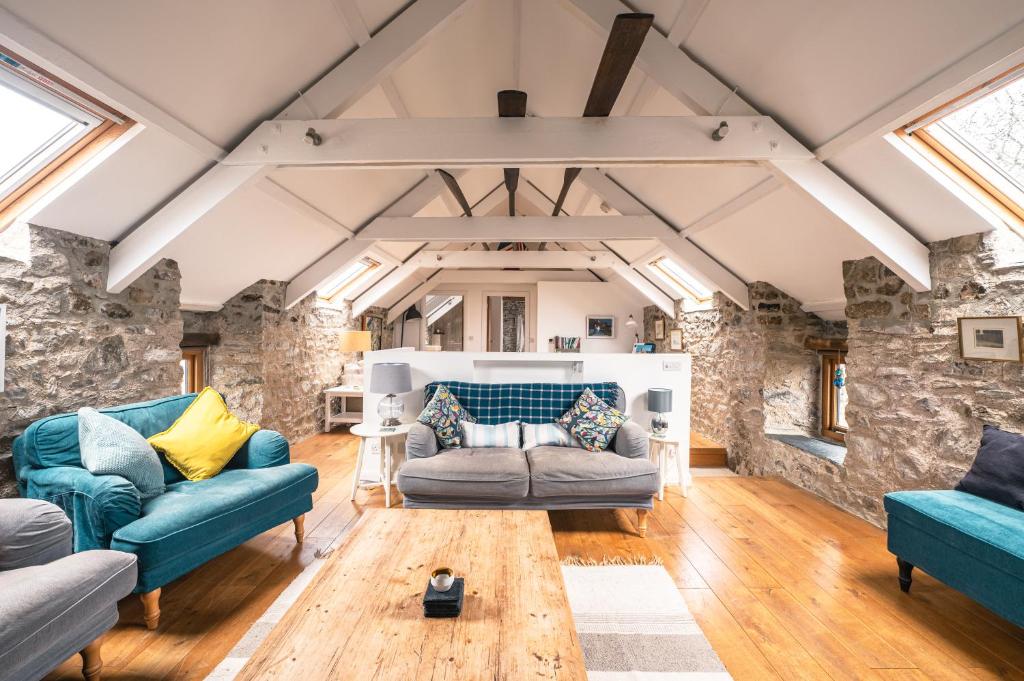 a living room with two couches and a table at Stunning Converted Granary in Heart of St Davids in St. Davids