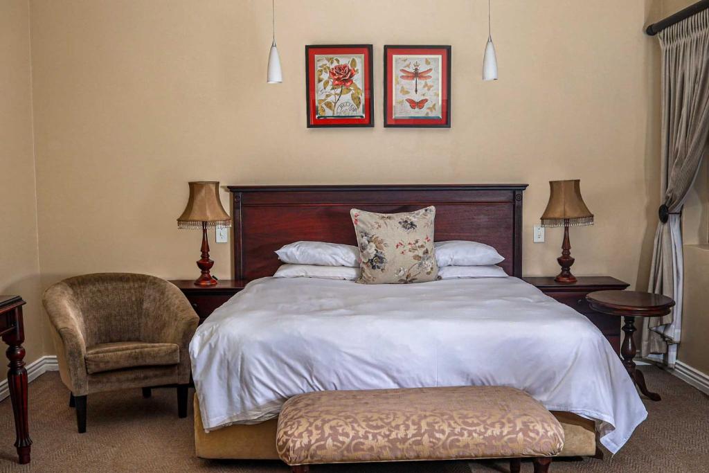 a bedroom with a bed and a chair and two pictures at Komani Resorts in Queenstown