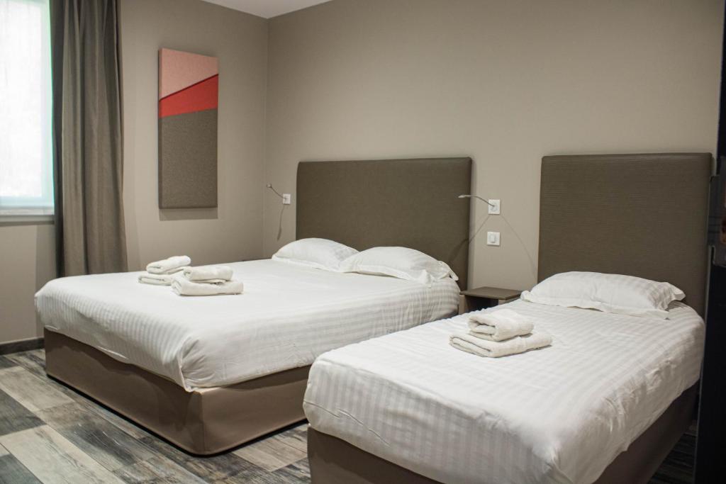 2 Betten in einem Hotelzimmer mit Handtüchern darauf in der Unterkunft La Source in Porcieu-Amblagnieu