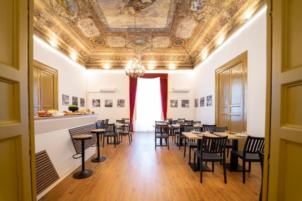 a dining room with tables and chairs and a ceiling at Ballaro' Hotel - Budget Room in Palermo