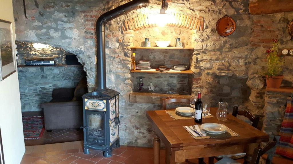 ein Zimmer mit einem Holztisch und einem Holzofen in der Unterkunft Cottage La Spagna in Pistoia