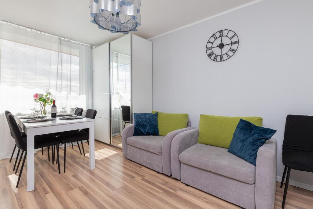 a living room with a couch and a table at Seaview Apartment Gdańsk Przymorze by Renters in Gdańsk