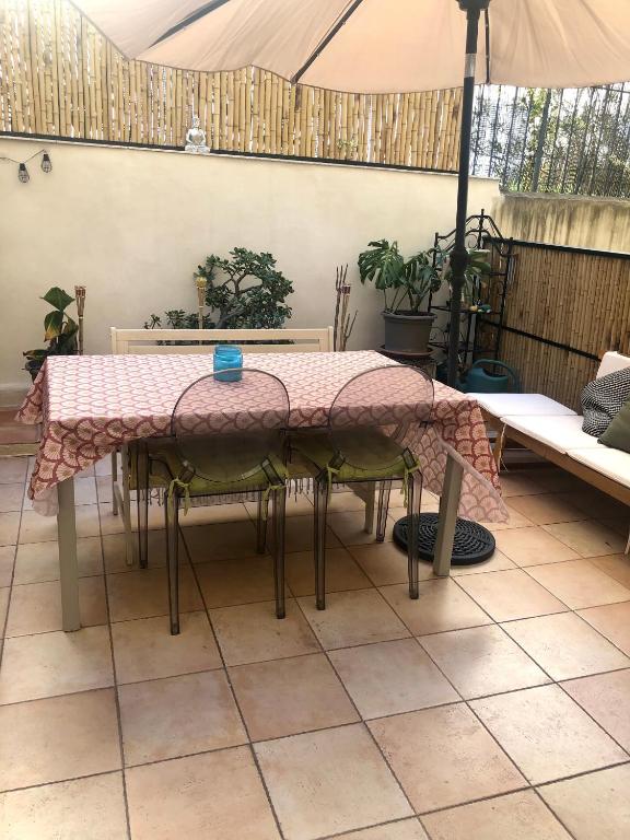 une table et des chaises avec une table et un parasol dans l'établissement Appartement zen avec patio et climatisation, en centre-ville, à Nice