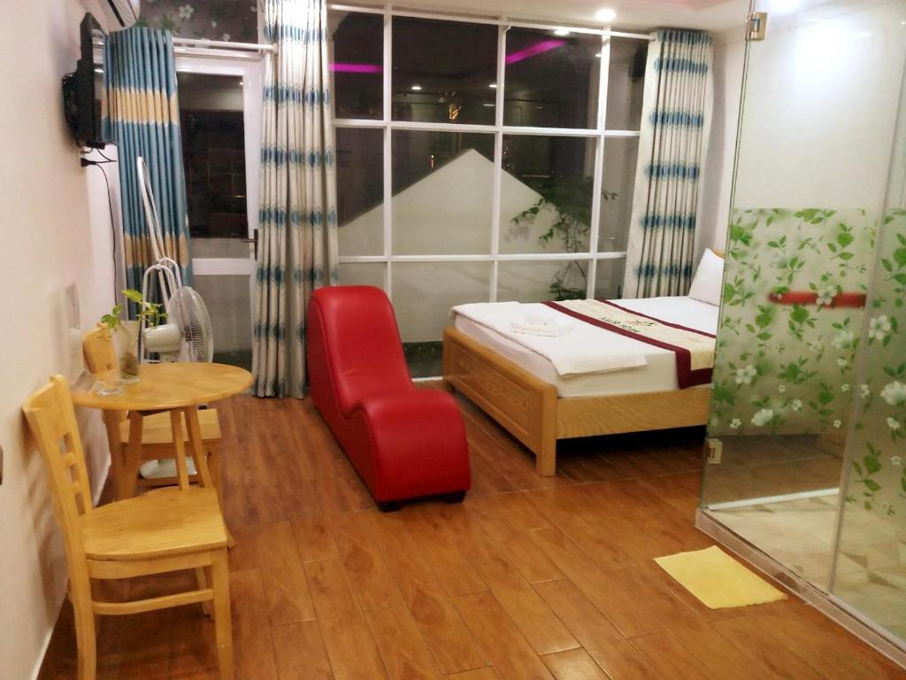 - une chambre avec un lit, une table et une chaise dans l'établissement Amor Hotel, à Hô-Chi-Minh-Ville