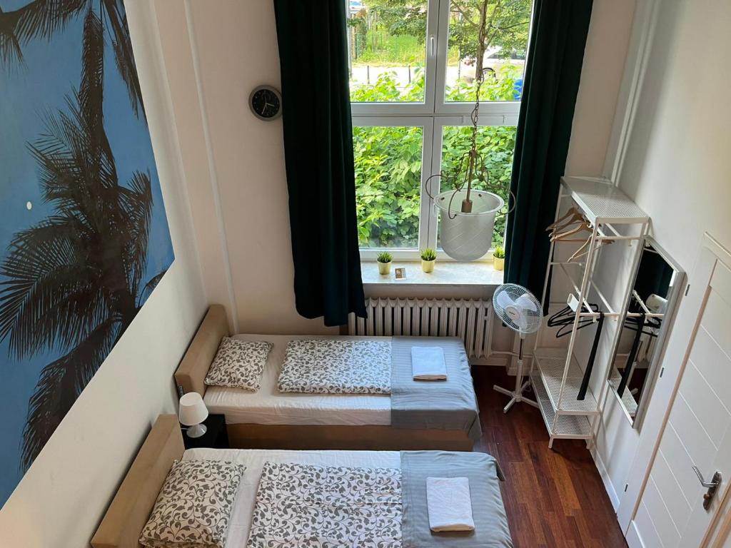 two beds in a room with a window at Labo Apartment Chmielna in Warsaw