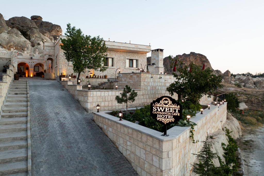 un edificio con un letrero al lado de una carretera en Cappadocia Sweet Cave Hotel, en Nevşehir