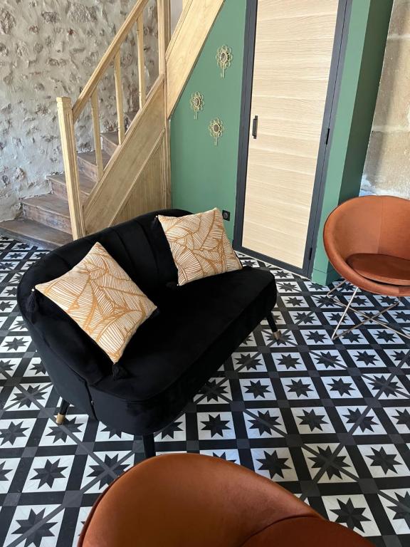 una silla negra sentada en un suelo blanco y negro en LE CHAPITRE - Agréable maison de ville en Autun