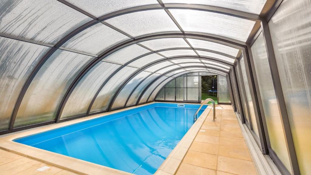 an indoor swimming pool with an arched ceiling and a swimming pool at Apartamenty Sun & Snow Villa Cztery Pory Roku in Jastrzębia Góra