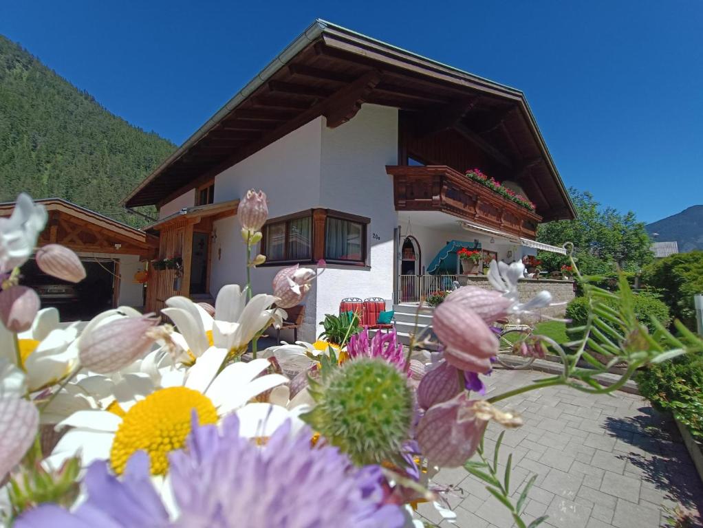 een klein huis met bloemen ervoor bij Ferienwohnung Sonja in Bach