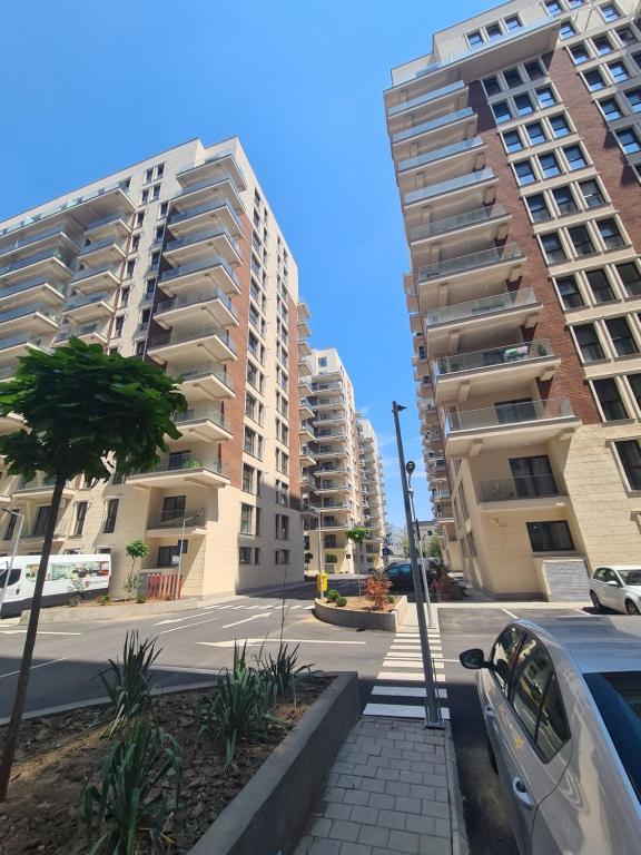 ブカレストにあるMoghioros Park Residence DUM3の高い建物が2棟と車が1台ある通り